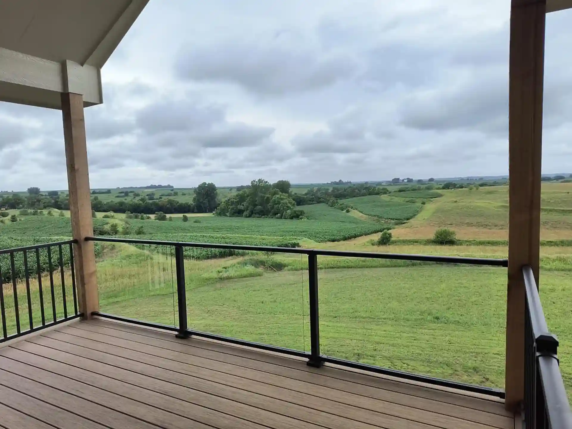 photo of an elevated covered deck with glass panels as part of the deck railing - Deck project ideas - Custom Deck Builders in Elkhorn NE